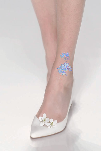 Sheer stockings with floral design, paired with white shoes on light gray background
