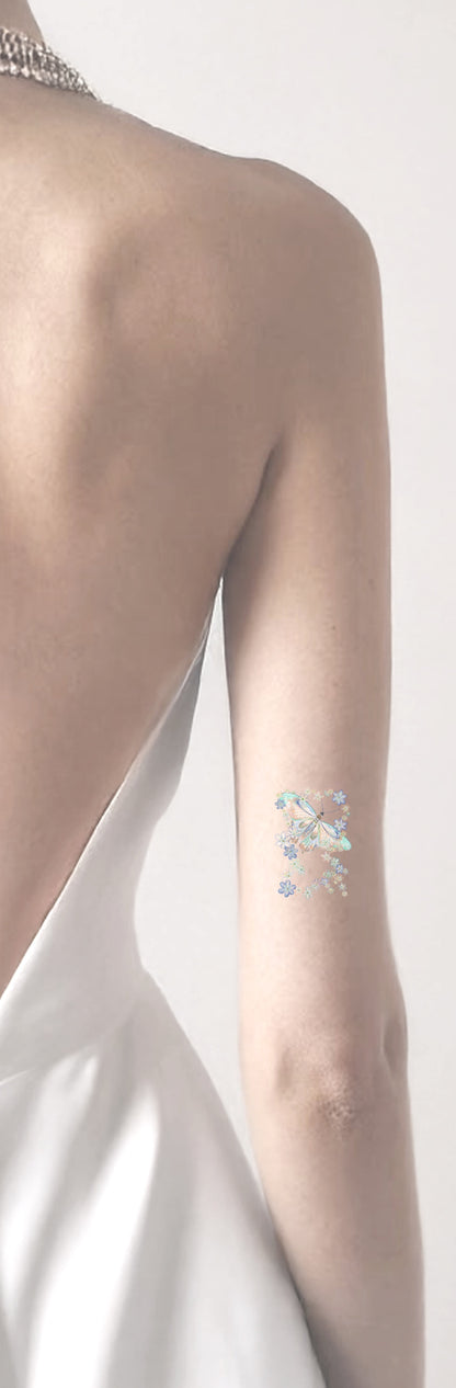 Tattoo of a blue flower design on a person's arm against a white background