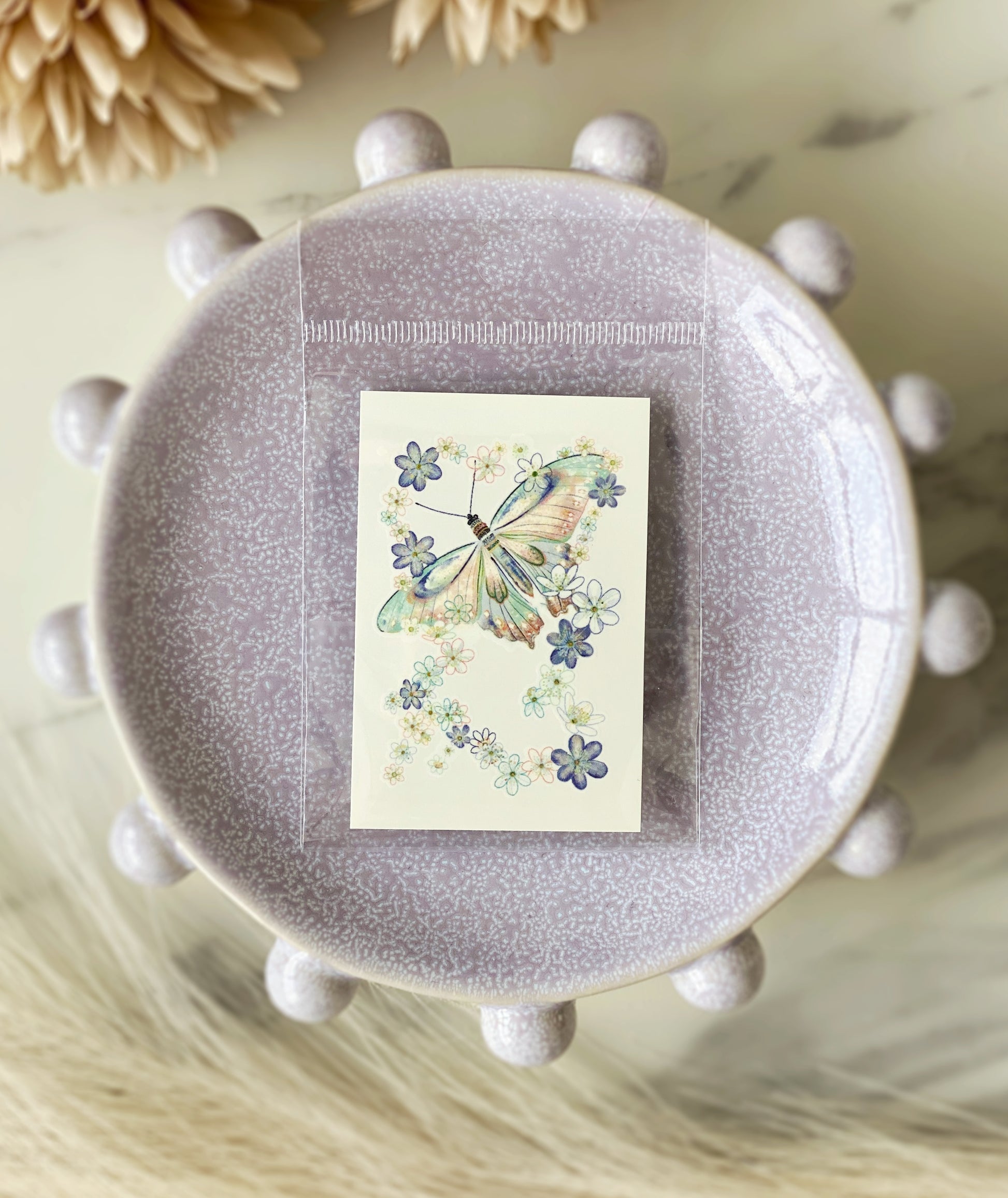 Close-up of blue-green butterfly floral temporary tattoo