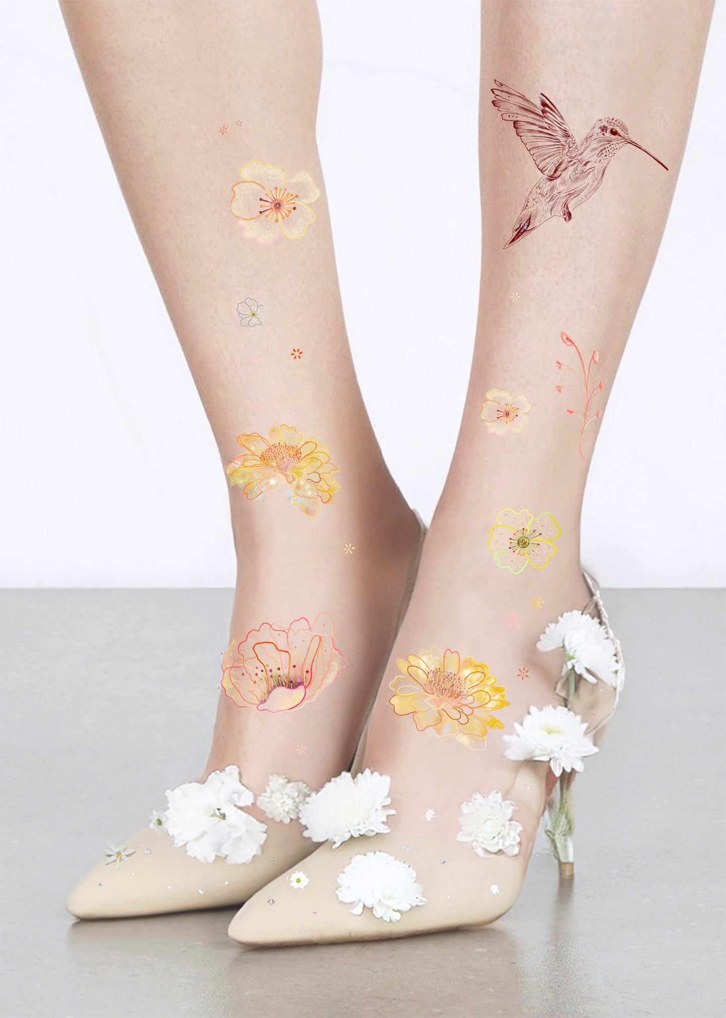 Sheer socks with floral and hummingbird designs, paired with white shoes on light background

