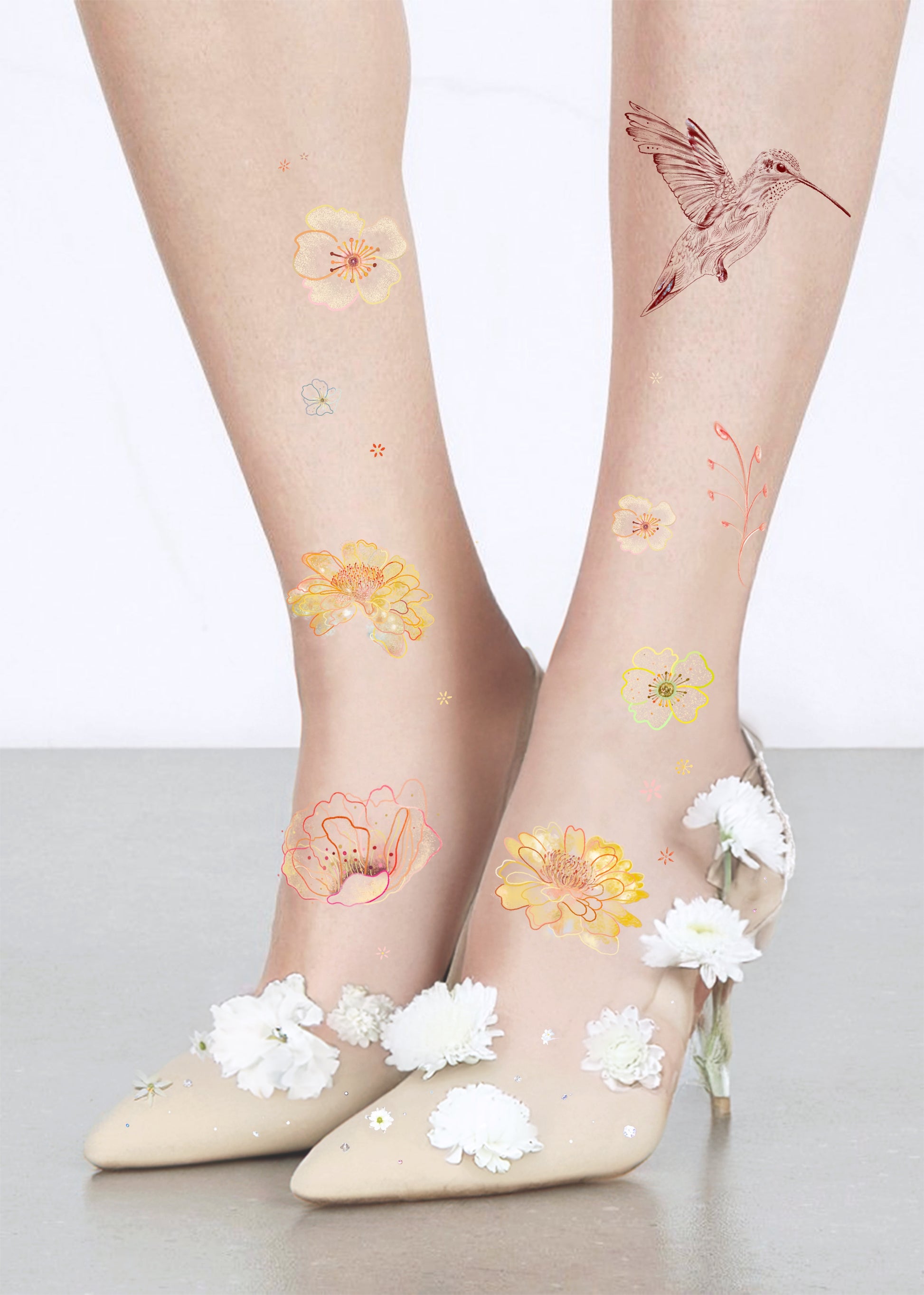 Sheer socks with floral and hummingbird designs, paired with white shoes on light background
