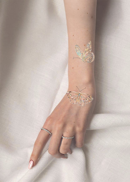 Hand with butterfly-shaped rings on a white background